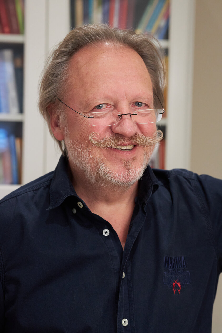 Andreas Lechner im Porträt vor einem Bücherregal